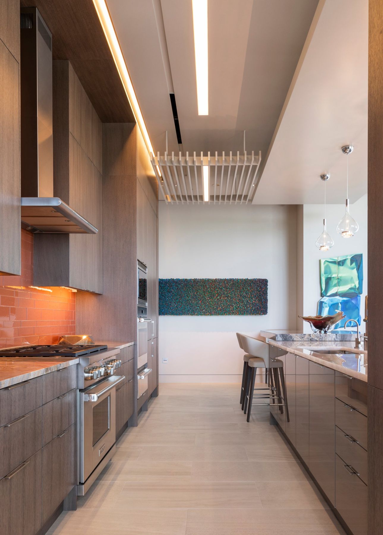 Galley kitchen with a linear light slot in the ceiling and under-cabinet lighting