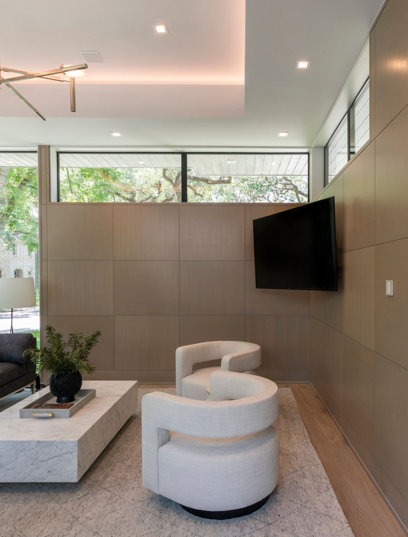 Oak-paneled sitting room with an angled TV, clerestory windows and a keypad on the wall